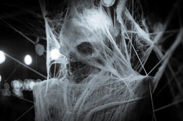 Skeleton decoration for Halloween wrapped in spider web and tissue