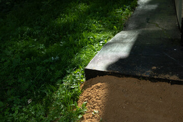 Sand at base of building. Wall of house. Building threshold.