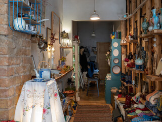 Stylish retro vintage interior. Brick wall. Hardwood floor. Decorations on wooden shelves. Knitted rug.