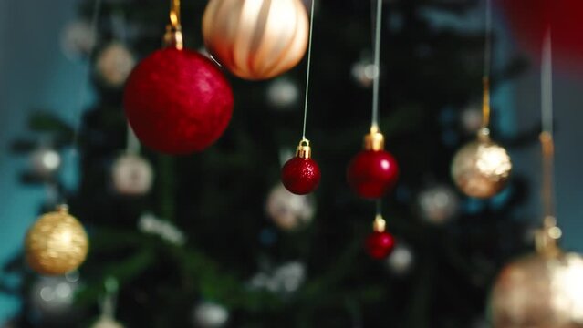 Christmas balls swinging in the space against the tree