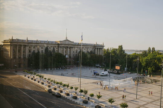 Mykolaiv, Ukraine - August 4, 2021. The building of the Nikolaev city executive committee, Council. The main grey city Square. People resting, Calm atmosphere in peaceful town before war. Upper view