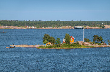 Helsinki, Finland - July 20, 2022: Luotsitupa yellow-red cabin for rent on its own tiny island in...