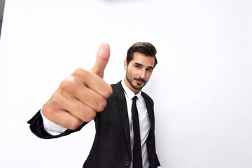 Portrait of a man in an expensive business suit close-up wide-angle lens pulls his hands into the camera with his mouth open and points his thumb up against a white background, copy space