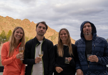 Family. Togetherness. Portrait of four siblings, brothers and sisters, holding a cup of white wine.
