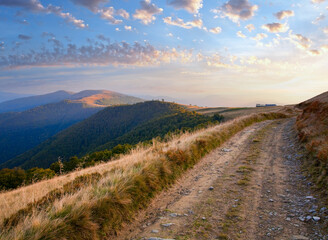 Carpathian Mountains (Ukraine) autumn landscape with cattle-breeding farm and country road.