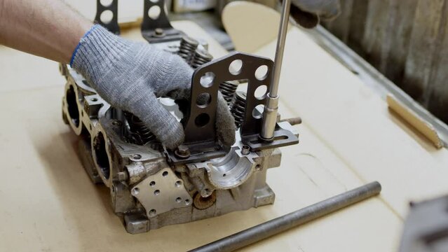close up view of disassembled sixteen-valve four-cylinder engine. day at car service, engine overhaul, close view of valve stem seals. Beautiful clean silver car engine.