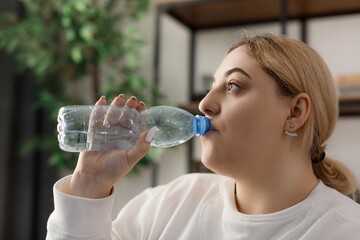 Woman drinking water after exercises