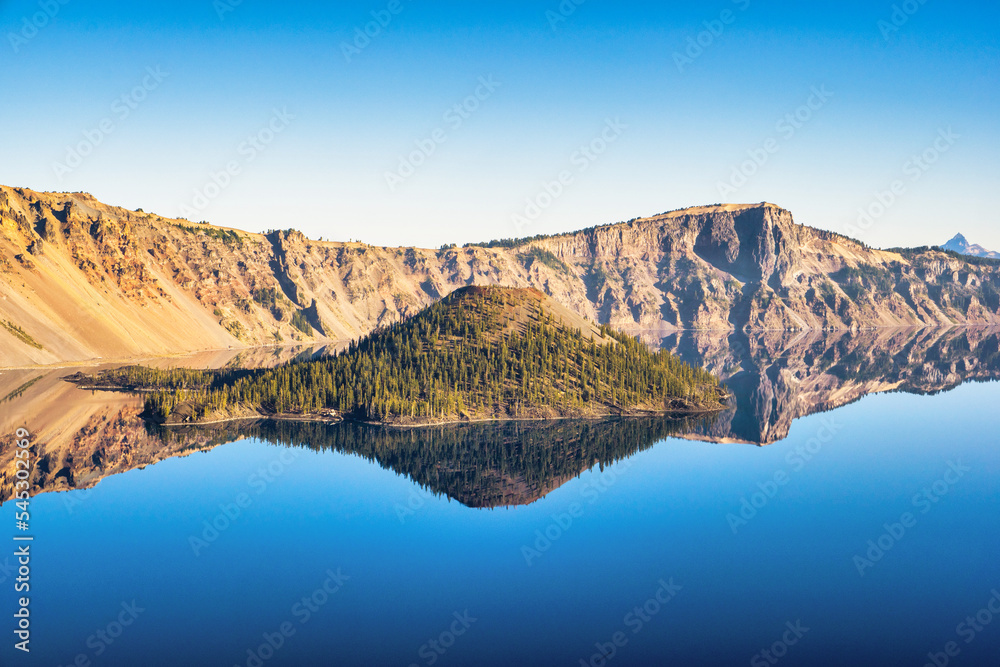 Wall mural view of wizard island in crater lake with mirror-like reflections on a calm and clear summer morning