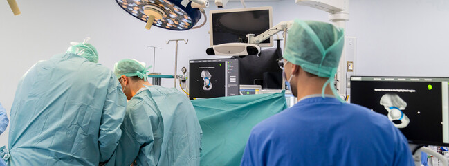 Team of doctor perform total hip arthroplasty replacement surgery in osteoarthritis patient inside the operating room. robot assisted robotic hip and knee replacement surgery	 - obrazy, fototapety, plakaty