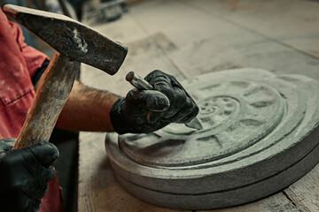 The craftsman works with stone with different tools. atmospheric photo. Sculpture making, handmade - obrazy, fototapety, plakaty