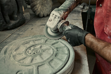 The craftsman works with stone with different tools. atmospheric photo. Sculpture making, handmade - obrazy, fototapety, plakaty