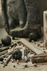 background with various tools for working with stone. Stone sculptures in the background in the workshop. hand made