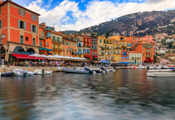 Seaside promenade with colorful houses and boats on the Mediterranean Sea in Villefranche sur Mer Old Town on the French Riviera, South of France