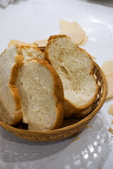 fresh made baked italian seasoned basket dinner rolls bread and butter bread in a basket on table crumbs messy dinner table fresh bread setting slices family portion meal kitchen counter mess dinner