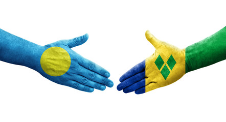 Handshake between Saint Vincent Grenadines and Palau flags painted on hands, isolated transparent image.