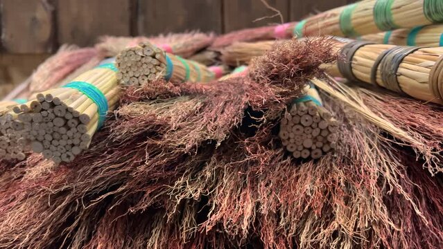 Handmade sorghum brooms lie on the DIY store or household store shelves. Closeup