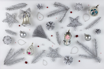 Christmas festive background. Silver decorations and silvery fir branches and cones on white...