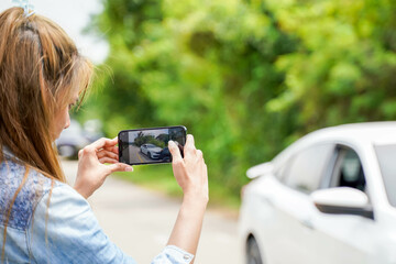 Closeup and crop female driver are using mobile phones to take photos as evidence for insurance claims.