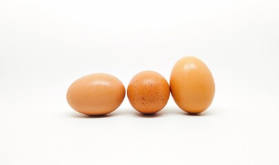 Three chicken eggs in a white background