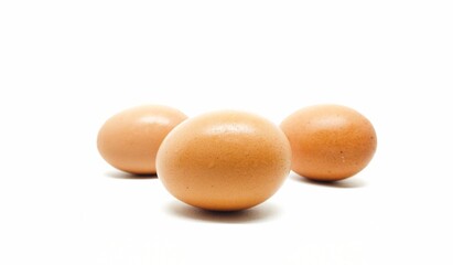Three chicken eggs in a white background