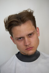 portrait of a young stylish guy dark haired European appearance close up, in a barbershop, model haircut, white background