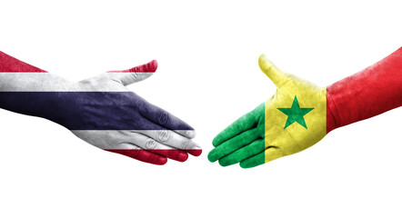 Handshake between Senegal and Thailand flags painted on hands, isolated transparent image.