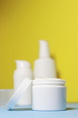 mock up of white jar of cream on a yellow background. Ready place for the label, copy space 