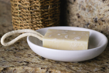 a bar of zero waste soap on white dish at bathroom sink