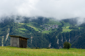 Fototapeta na wymiar Eine Hütte vor einer Gemeinde in den ALpen