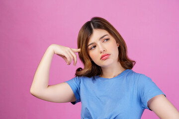 Portrait of young woman wearing casual t-shirt thinking and imagination isolated over pink background