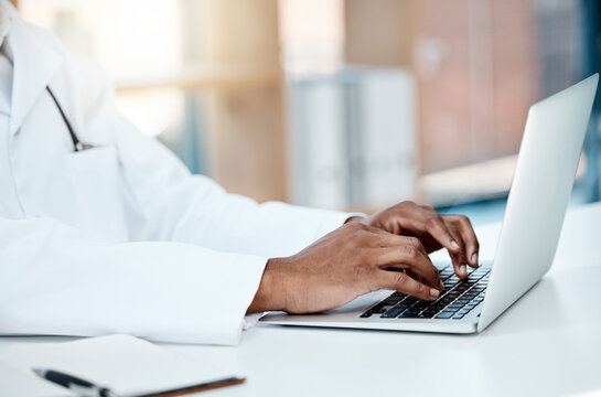 Doctor, hands and typing on laptop in office, working on research or online consultation. Healthcare, computer and black male physician writing patient report, data record or checking medical email.