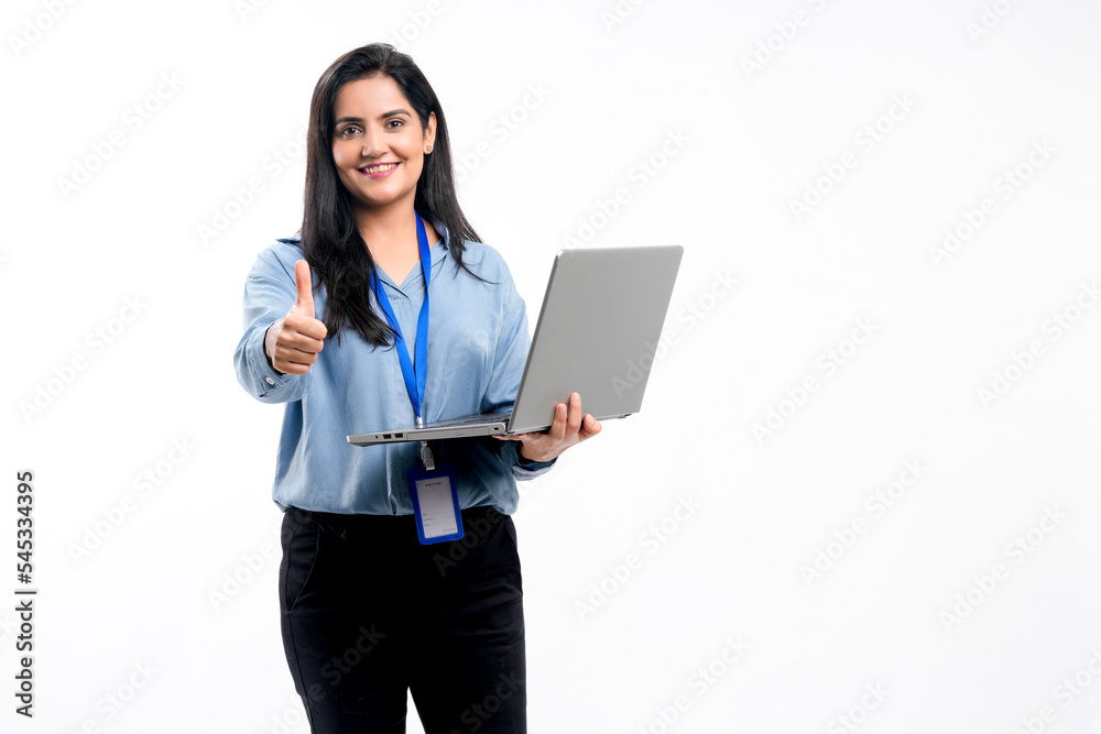 Wall mural Indian businesswoman or employee using laptop and showing thumps up on white background.