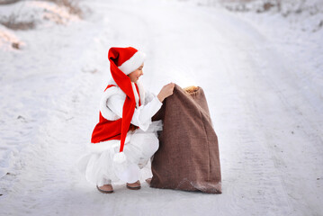 A girl in a New Year's costume with gifts from Santa Claus, not on the street.