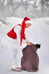 A girl in a New Year's costume with gifts from Santa Claus, not on the street.