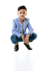 A 10-year-old Asian boy in a casual jacket is sitting smart and happy looking at the camera against a white isolate background. - 545335379
