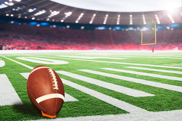 American football field with goal post and ball on kicking tee in crowded stadium