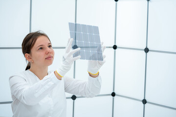 young woman controls a transparent solar battery element in a renewable energy laboratory
