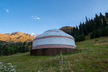 Kazakh guest yurt on the background of mountains not far from Almaty in early autumn. A beautiful landscape with a traditional nomad house in the mountains of Almaty.