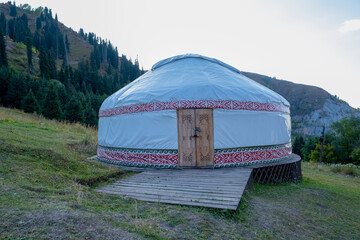 Kazakh guest yurt on the background of mountains not far from Almaty in early autumn. A beautiful landscape with a traditional nomad house in the mountains of Almaty.