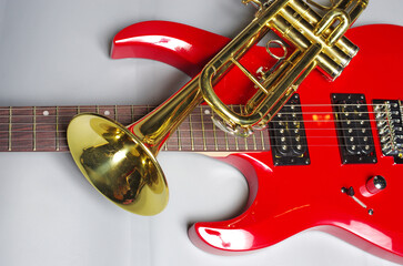 Obraz na płótnie Canvas Electric guitar and golden trumpet on a light background. 