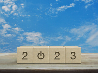 2023 start up business icon on wood block cubes on wooden table over blue sky with white clouds, Happy new year 2023 cover concept