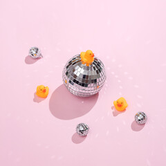 Creative medicine layout. Rubber ducks with disco balls on a pink background. Retro aesthetics of the 80s. Surreal idea. Party concept. Conceptual pop