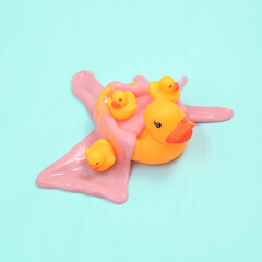 Creative minimalist layout. Rubber ducks with slime on blue background. Surreal summer idea. Conceptual pop