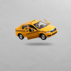 Mini taxi car levitating on gray background with shadow