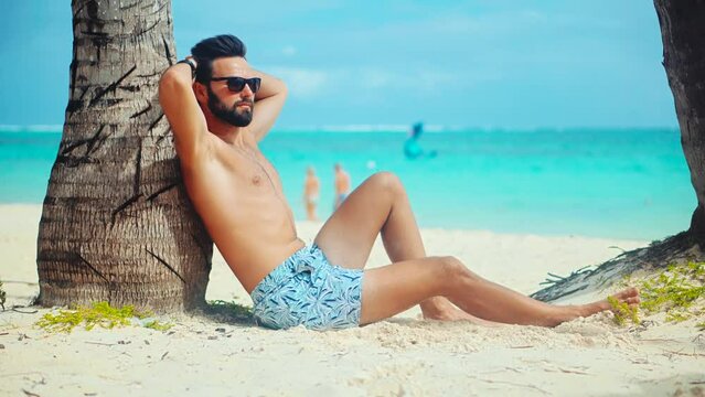 tanned man relaxing white sand ocean beach