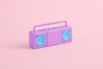 Plastic miniature boombox audio player on pink background