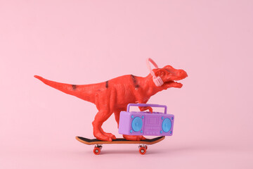 Toy red dinosaur tyrannosaurus rex with boombox audio player and headphones, ride on skate, pink...