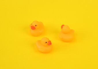 Rubber little ducklings on a yellow background