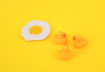 Rubber ducks with scrambled eggs on a pink background. Creative layout