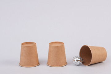 Gambling with cups. Christmas ball under the cup